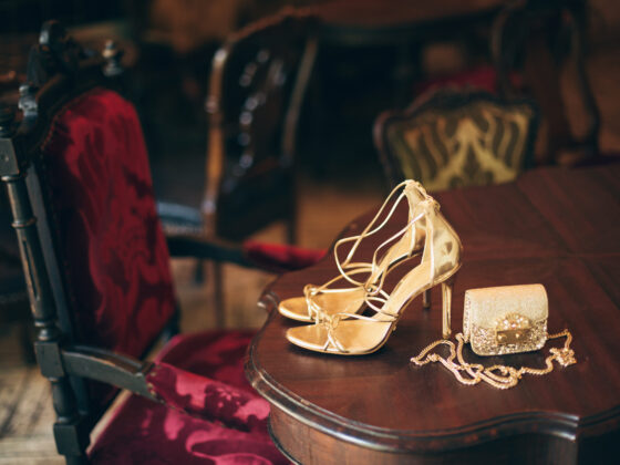 Zapatos dorados con bolso sobre una mesa